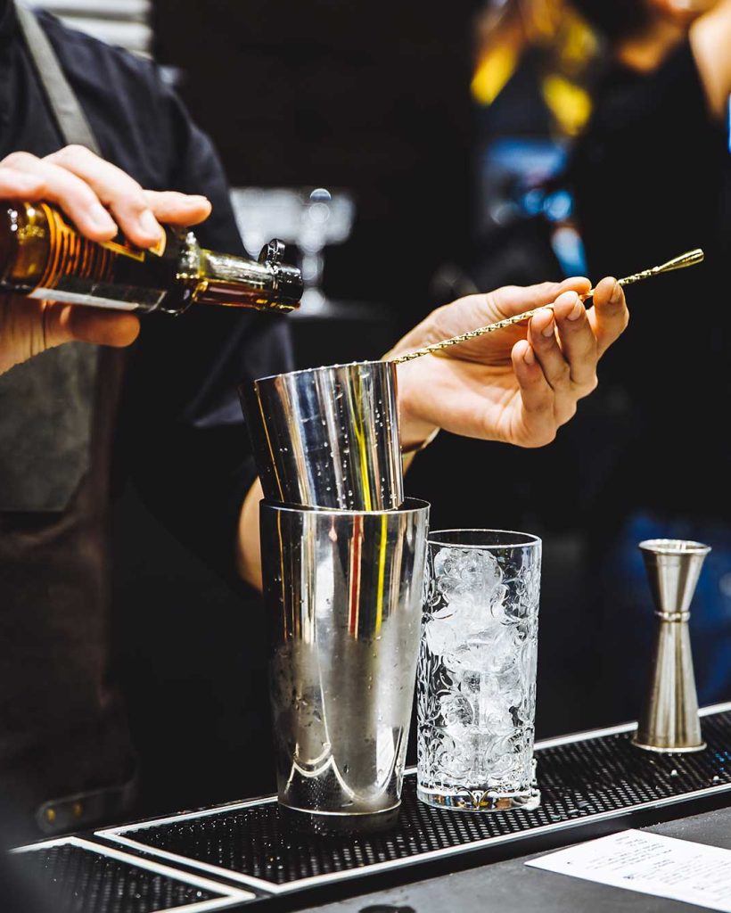 barman-at-work-pouring-hard-spirit-into-glasses